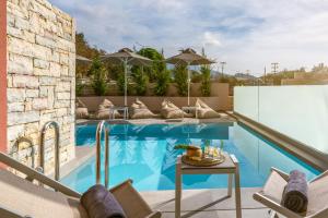 a patio with a swimming pool with chairs and a table at Aria Luxury Residence in Syvota