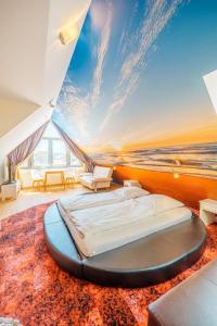 a large bed in a room with a view of the ocean at Bavaria Lifestyle Hotel in Altötting