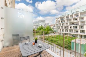 balcón con mesa y vistas a un edificio en Appart’City Confort Reims Centre, en Reims