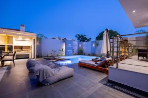 a patio with a pool and a couch and a table at Mr & Mrs Grey Villas-Private Pool Luxury in Zakynthos near Laganas in Ambelókipoi