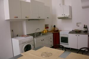 カストリニャーノ・デル・カーポにあるVacanza serenaの白いキャビネット、シンク、食器洗い機付きのキッチンが備わります。
