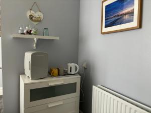 una habitación con un tocador con un microondas. en Calm sea guesthouse en Weymouth