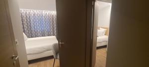 a room with a couch and a chair and a window at Geographotel Paris-Roissy CDG Airport in Le Mesnil-Amelot