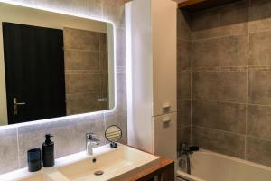 ein Badezimmer mit Waschbecken, Spiegel und Badewanne in der Unterkunft CORTO 4 pers Cœur Vieille Ville Parking in Boulogne-sur-Mer