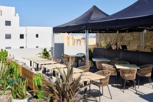 rząd stołów i krzeseł na patio w obiekcie Stic Urban Hotel & SPA w mieście San Antonio
