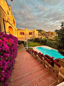 una casa con piscina y algunas flores rosas en Villa Vie En Rose en Sorrento