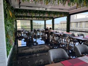 a restaurant with tables and chairs and plants at Madina-ZamZam Halal Hotels Group in Baku
