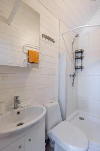ein weißes Bad mit einem Waschbecken und einem WC in der Unterkunft Audronašų Vilos in Šventoji