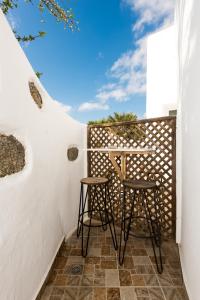 a small balcony with two stools on a white wall at Olympia in Mikonos
