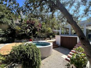 a garden with a hot tub in a yard at VILLA HELIOS - vue mer, terrasse, jardin, piscine, parking in Marseille