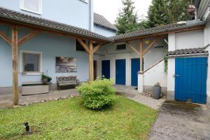 a house with a blue door and a yard at Quartier Sängerstadt in Finsterwalde