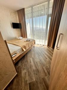 a bedroom with a bed and a large window at Green Cape Tower in Batumi