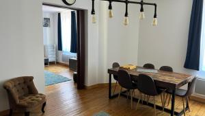a dining room with a wooden table and chairs at Sherlock Home in Le Tréport