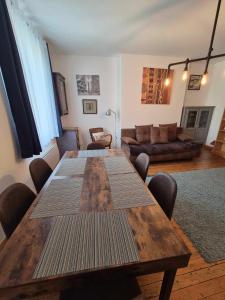 a living room with a wooden table and a couch at Sherlock Home in Le Tréport +16 photos