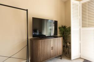 a flat screen tv sitting on a stand in a room at Greystones Harbour Studio in Na Clocha Liatha