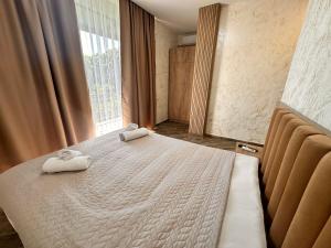 1 dormitorio con 1 cama con 2 toallas en Green Cape Tower, en Batumi