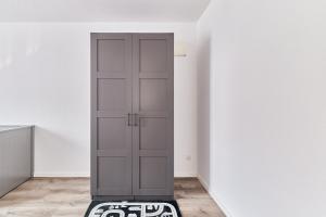 einen grauen Schrank in einem weißen Zimmer mit einem Teppich in der Unterkunft Elegantes 2 Zimmer Apartment Neubau Top Lage in Mannheim