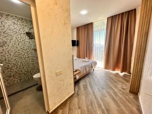 a bedroom with a bed and a bathroom with a shower at Green Cape Tower in Batumi