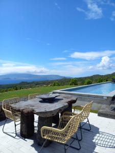 a stone table and chairs on a patio with a pool at PicoTerrace in Madalena