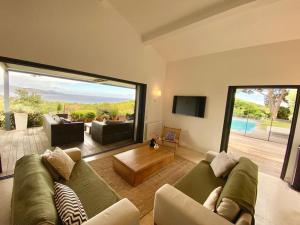 un soggiorno con due divani e una grande finestra di Magnifique villa vue mer a Sainte-Maxime