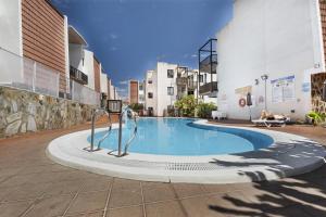 a swimming pool in the middle of a building at Bonita Apto Nieves in Playa de Santiago