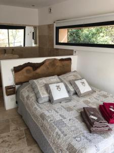 um quarto com uma cama com almofadas em Lodge entre ciel et mer em Saint-Cyr-sur-Mer
