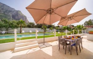 een tafel met stoelen en een parasol naast een zwembad bij Pet Friendly Home In Palermo With Kitchen in Palermo