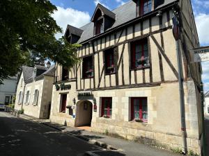 an old building with red doors and windows on a street at Hôtel Le Blason in Amboise