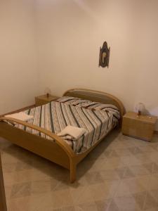 un letto in una camera con due comodini e due tavoli di Casa vacanza Lipari a Città di Lipari