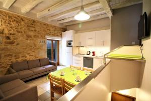 a kitchen and a living room with a table at Gites La Palombière La Muzardie in Bézenac