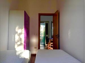 ein Schlafzimmer mit einem Bett und einer offenen Tür in der Unterkunft Villa Margherita in Vieste