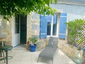 un patio con una silla, una mesa y una ventana en La Chambre de Veyrines en Mérignac