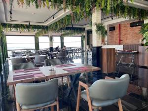 um restaurante com mesas, cadeiras e plantas em Venera Hotel em Baku