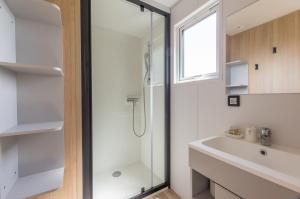 La salle de bains est pourvue d'une douche et d'un lavabo. dans l'établissement Camping le Mas de Riri, à Celles