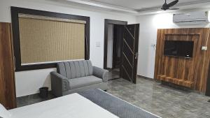 a living room with a chair and a television in a room at Jhansi Castle Inn in Jhānsi