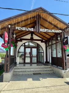 a building with a sign for a restaurant at PENSIUNEA ANA in Piatra Neamţ