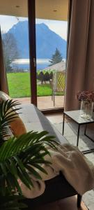 Una habitación con vista a un patio con una mesa y un sofá. en Inspiration - zwei Terrassen mit Seeblick und Garten, en Altmünster