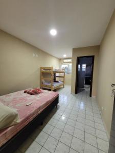 ein Schlafzimmer mit einem Bett und einem Stuhl darin in der Unterkunft Cantinho do Mar Pousada in Bertioga