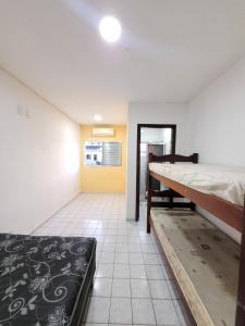 Habitación con 2 camas en una habitación con paredes amarillas. en Cantinho do Mar Pousada, en Bertioga