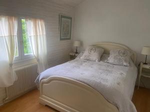 a bedroom with a white bed with two windows at PLIM CIE in Chaponost