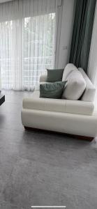 Sofá blanco con almohadas en una habitación con ventana en Luna Alacati, en Alacati
