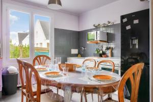 a kitchen with a table and chairs and a table and a kitchen at Concarneau - 300m des plages in Concarneau +17 photos