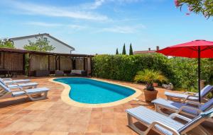 ein Swimmingpool mit Stühlen und einem Sonnenschirm in der Unterkunft 5 Bedroom Nice Home In Pinezici in Pinezici + 37 Fotos
