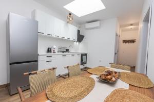 布尔加斯The Central House 2的一间带桌椅的厨房和一间带白色橱柜的厨房