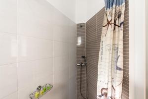a bathroom with a shower with a shower curtain at Olympia in Mikonos +98 photos