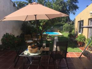 a table with an umbrella on a patio at Habitación con Baño Privado en Casa del Zorzal en Tandil in Tandil