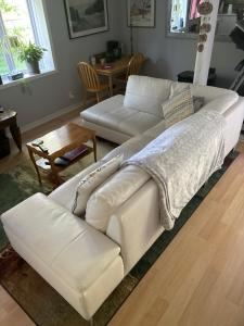 um sofá de couro branco numa sala de estar com uma mesa em Nature Retreat in the city em Ottawa