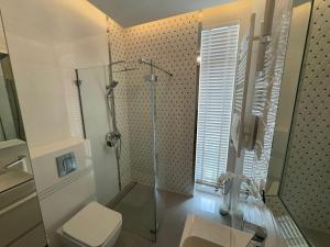 a bathroom with a glass shower and a toilet at Apartament Glamour 10B- Premium z basenem in Łukęcin