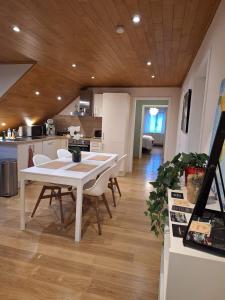 uma cozinha e sala de jantar com uma mesa branca e cadeiras em Gite L'Ecureuil - Appartement 4 personnes à Wépion (Namur) em Namur