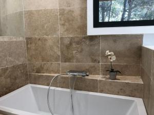 La salle de bains est pourvue d'une baignoire avec un robinet. dans l'établissement Lodge entre ciel et mer, à Saint-Cyr-sur-Mer